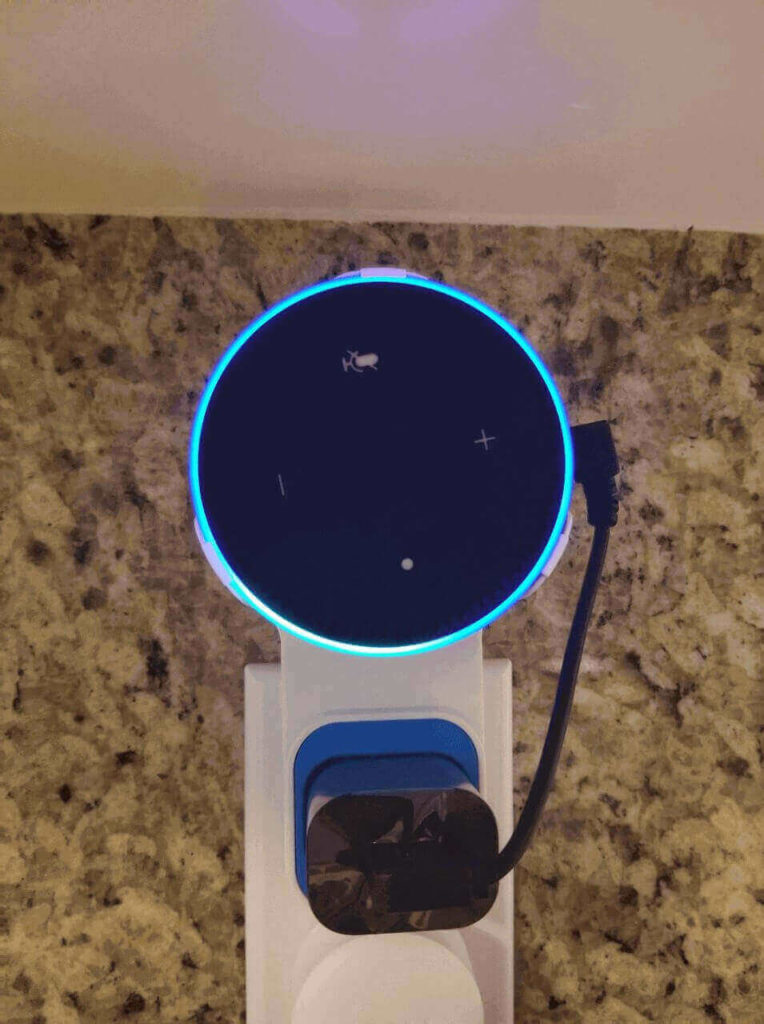 An echo dot plugged into a power outlet to make it work