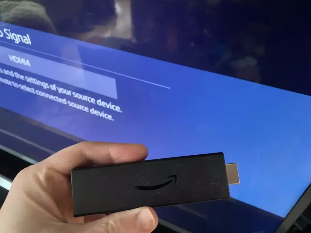 A Fire TV Stick in front of a new TV that is not getting a signal